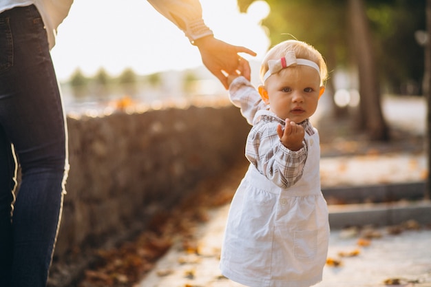 Little girl holding mother's hand in park
