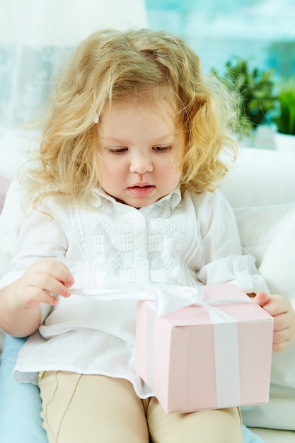 Little girl holding pink present