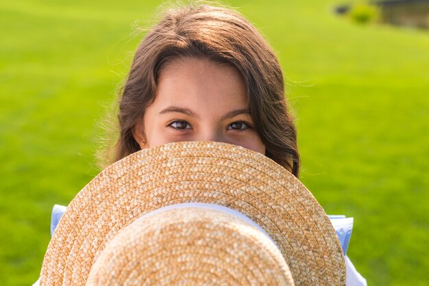 Little girl holding a straw hat