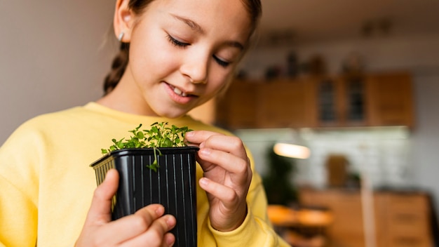 小さな植物を持つ家の小さな女の子