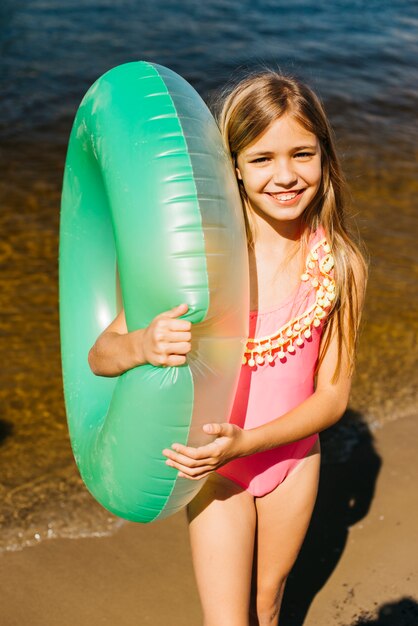 Little girl hugging air swimming tube