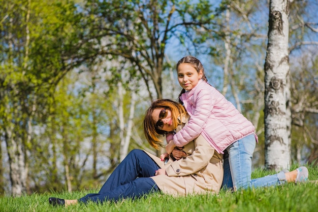 公園の中で母親を抱擁している少女