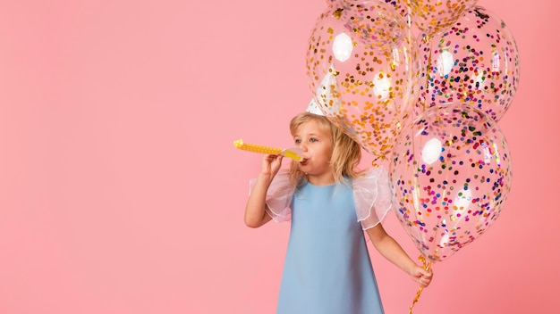 Бесплатное фото Маленькая девочка в костюме с воздушными шарами