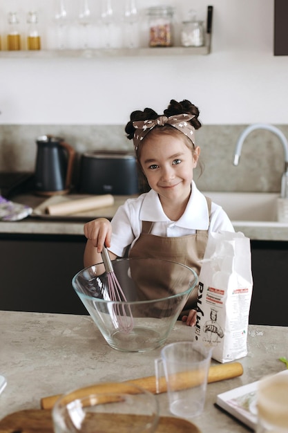 小さな女の子がキッチンでクッキーを調理しています