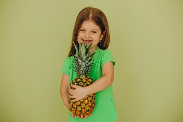 Little girl isolated holding pineapple