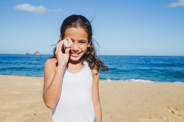 Little girl joking with a seashell