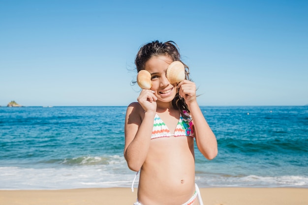 Little girl joking with shells