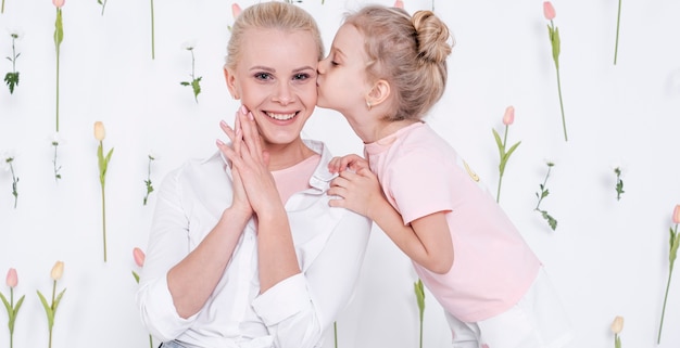 Free photo little girl kissing happy mother