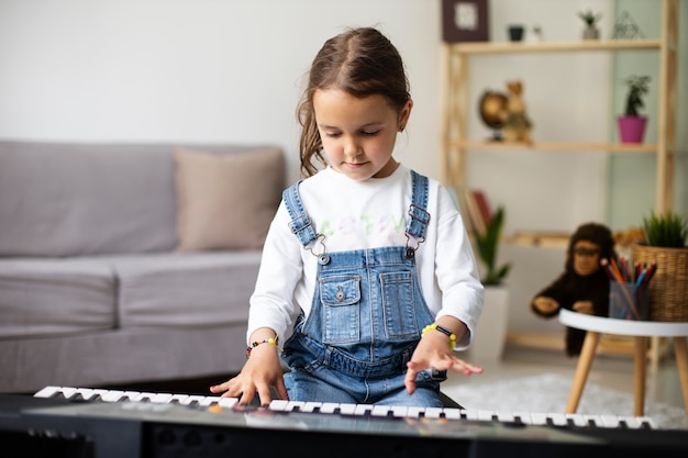 Free photo little girl learning how to play the piano