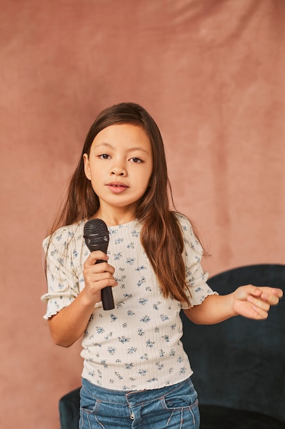 Little girl learning how to sing at home