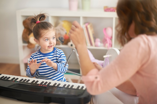 Foto gratuita bambina che impara a suonare il pianoforte