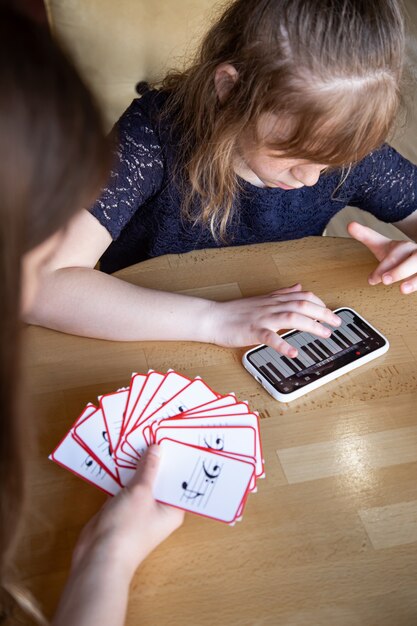 어린 소녀는 특별한 음악 카드를 사용하여 장난스럽게 음을 배웁니다.