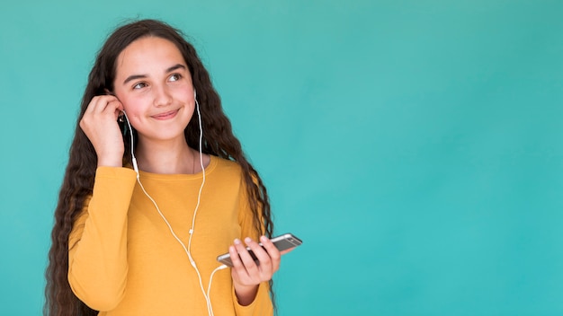 Little girl listening to music on earphones