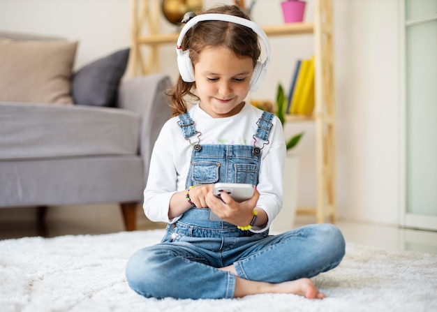 Little girl listening to music through headphones