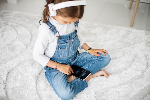 Little girl listening to music through headphones