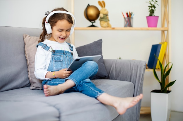 Little girl listening to music through headphones