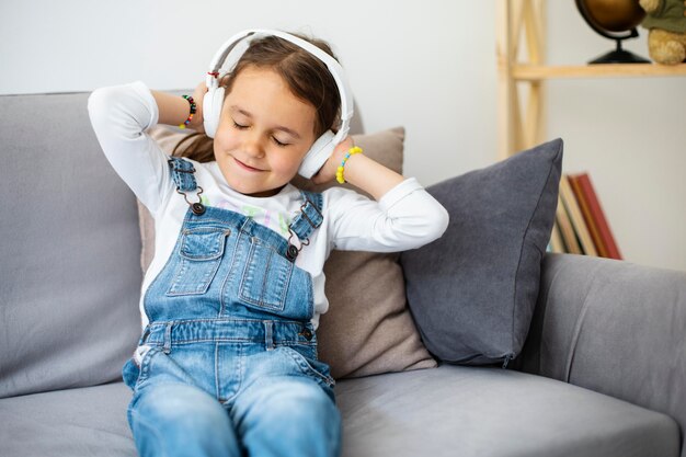 Little girl listening to music through headphones