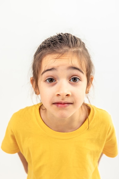 Free photo little girl looking directly at the camera on a white background isolated