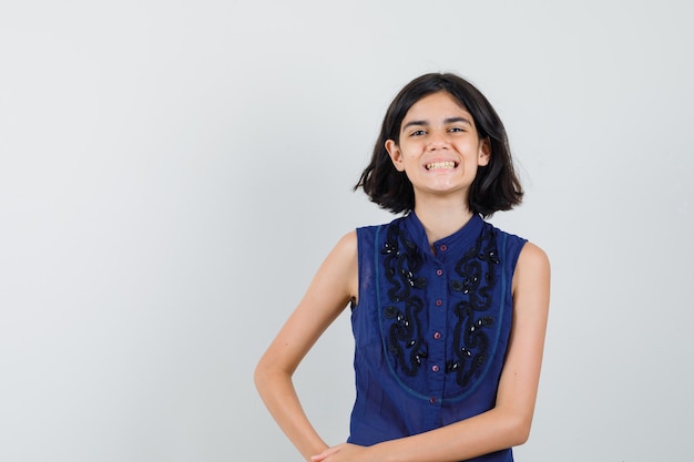 Free photo little girl looking at front in blue blouse and looking happy.