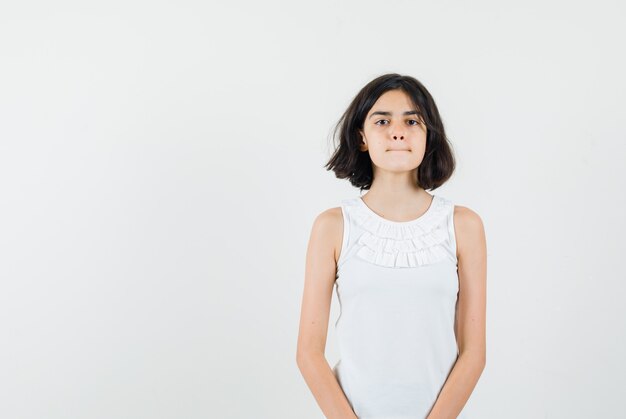 Little girl looking at front in white blouse and looking serious. front view.