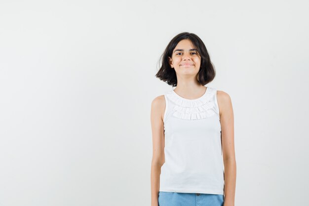 Little girl looking at front in white blouse, shorts and looking nice , front view.