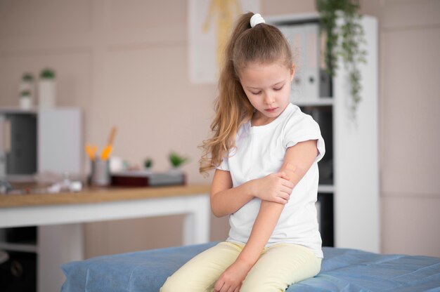 little girl looking at her arm after being vaccinated