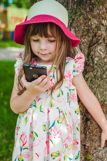 Foto gratuita bambina che esamina uno smartphone