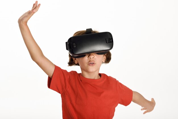 Little girl looking in VR glasses and gesturing with his hands.