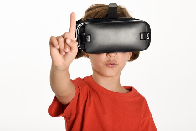 Little girl looking in VR glasses and gesturing with his hands.