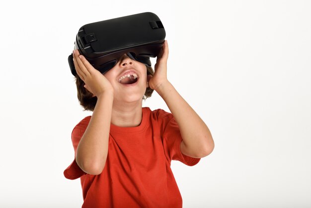 Little girl looking in VR glasses and gesturing with his hands.