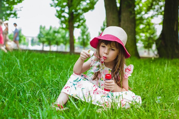 Little girl making bubbles with a pompous