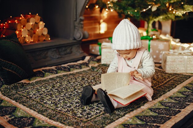 Little girl near sitting christmas tree