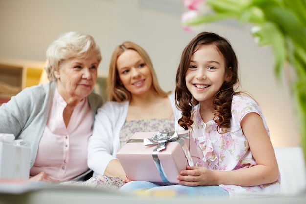 Little girl opening a gift at home