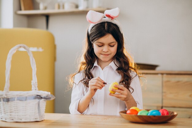 Little girl painting eggs for easter