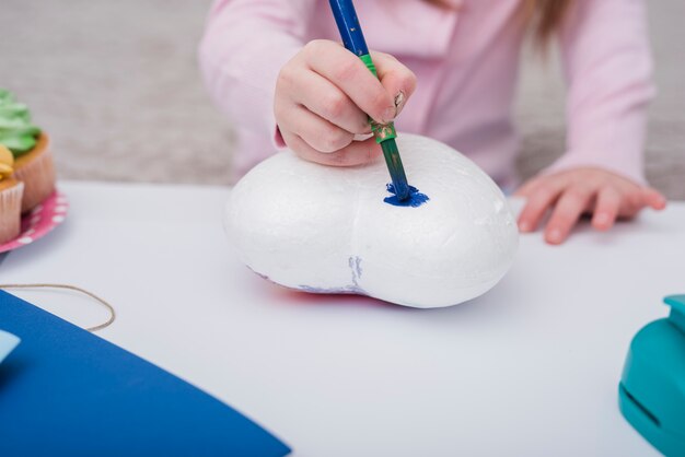 Little girl painting a heart