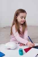 Бесплатное фото Маленькая девочка рисует кистью