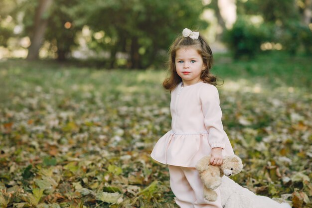 Little girl in a park in a pink dress playing