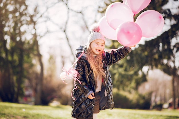 Little girl in a park playing on a grass