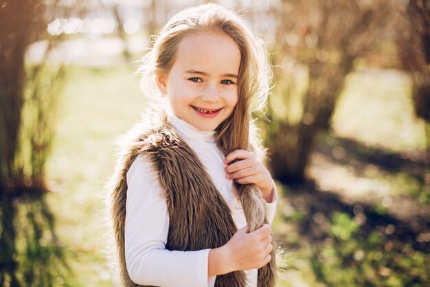 Little girl in a park playing on a grass