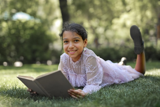 little girl in a park reads a book