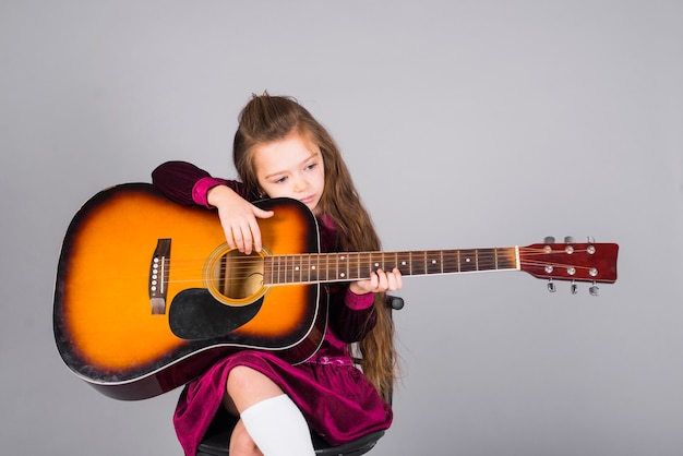 Foto gratuita bambina che suona la chitarra acustica