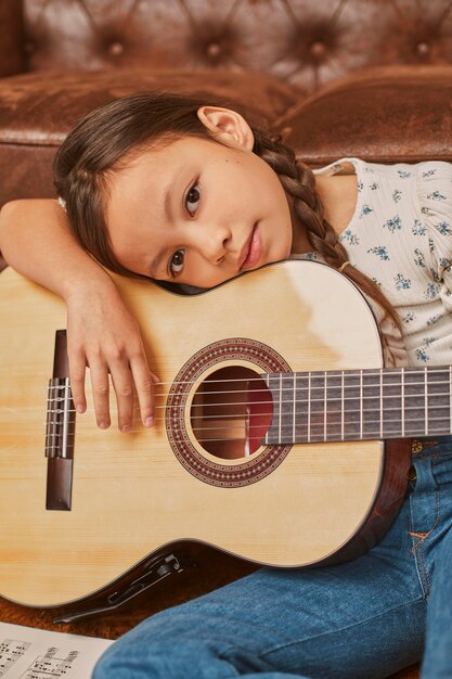 Little girl playing guitar at home