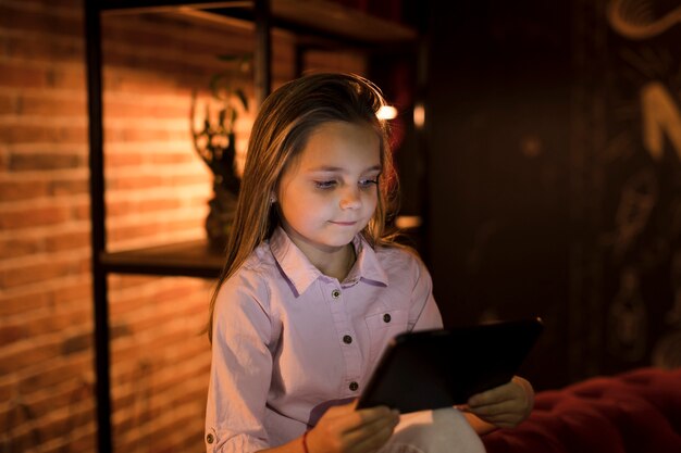 Little girl playing on her tablet