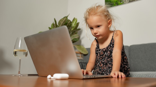 Little girl playing on laptop. High quality photo