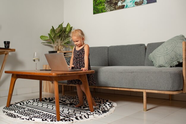 Little girl playing on laptop. High quality photo