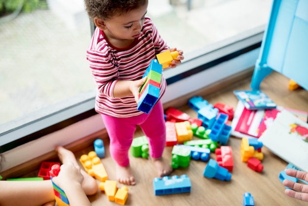 Free photo little girl playing with building blocks