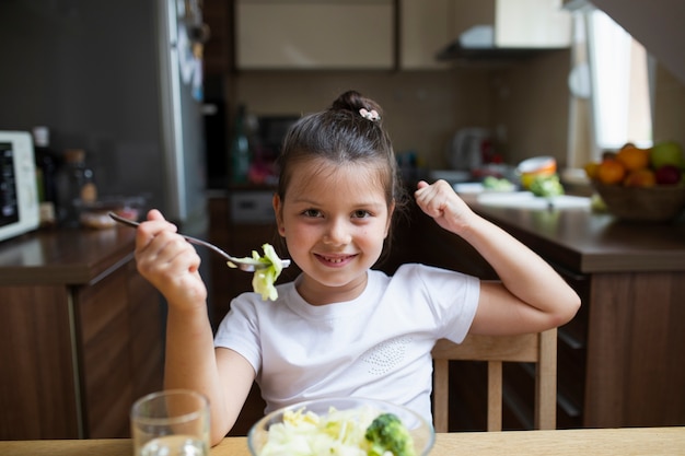 Little girl playing with food while eating