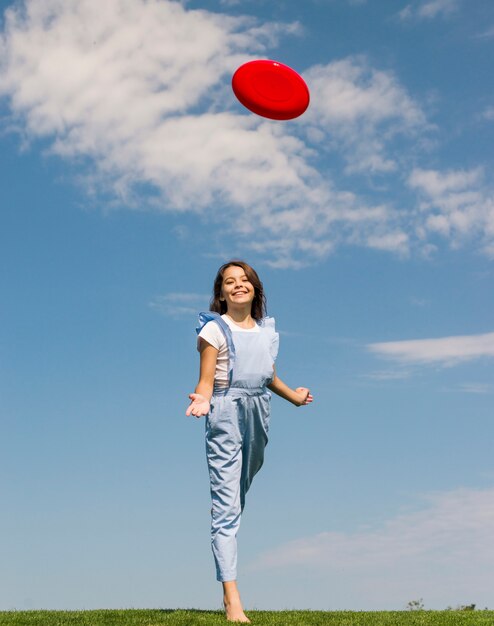 Little girl playing with frisbee outdoors