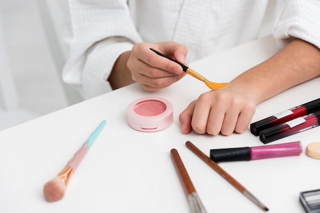 Little girl playing with her mothers cosmetics close-up