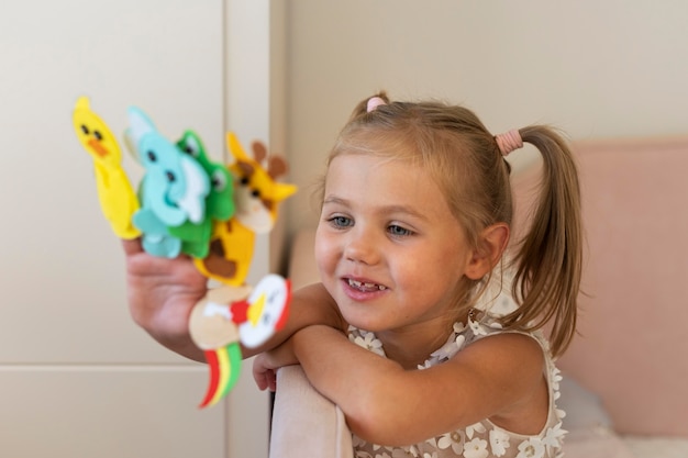 Little girl playing with her puppets at home